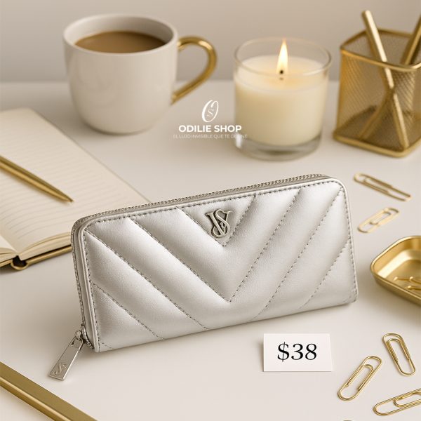 Billetera compacta gris de Victoria's Secret con cierre de cremallera. Diseño elegante y funcional para el uso diario. Precio regular $38.